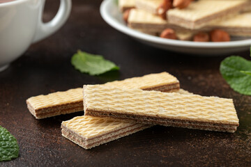 Tasty wafer biscuits with chocolate on rustic table