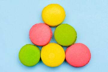 different multicolored macaron cakes on a blue background