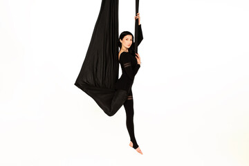 Air yoga isolated on the white background. Woman doing stretching on black hammock.