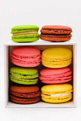 multicolor macaron cakes in a white cardboard box on a white background