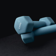 2 kg dumbbells isolated on dark background - home fitness and workout.