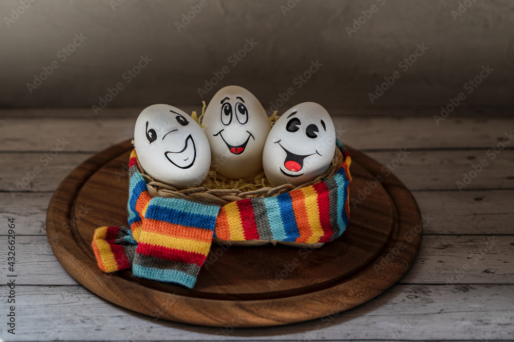 Wall mural easter white eggs with painted faces, family of eggs, three in one basket