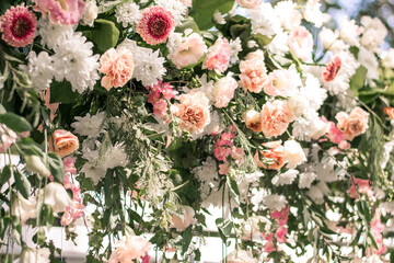Wedding ceremony. Very beautiful and stylish wedding arch, decorated with various fresh flowers, standing in the garden.