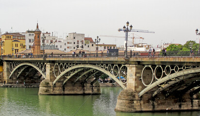 Fototapeta na wymiar Famous and historic Triana bridge in the city of Seville, Andalusia, Spain