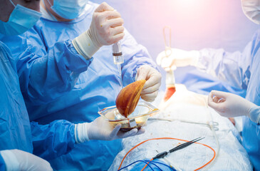 Breast augmentation under the guidance surgeons team in surgical operating room.