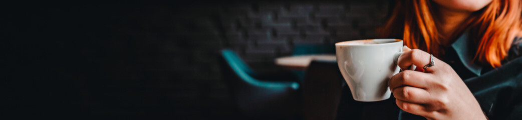 woman hands holding a white cup of tea or coffee in cafe