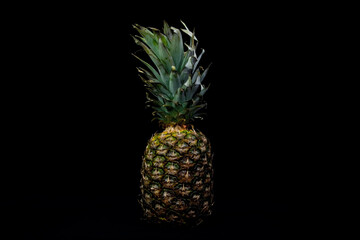 Ripe juicy pineapple on a black background.