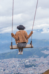 Young cute female steaming in the air on a large swing