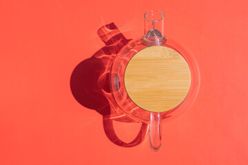 glass teapot with a hard shadow on a colored background