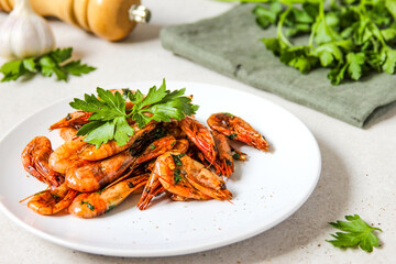 Grilled shrimps with garlic, parsley and black pepper on the white background.