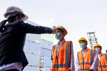engineer women hold digital thermometer, measure temperature for screen workers with face mask,