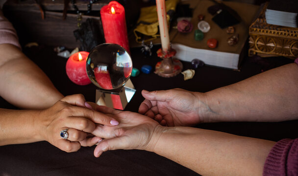 Palm rider - Seance of fortune telling on a hand, candles and fortune-telling witch objects. The concept of divination, astrology and esotericism