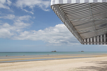 Obraz premium grey and white striped awning with beach background.
