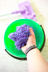 Washing a doormat in a bucket of water. Room cleaning.