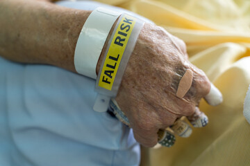 A hospital patient wearing a fall risk bracelet and fingers separation pad anti-bedsore elder...