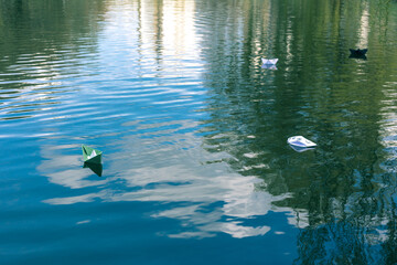 Many paper skiffs float on the water