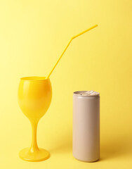 Yellow cocktail glass summer drink beverage juice with yellow straw and gray grey tin can soda soft drink concept minimal aesthetic