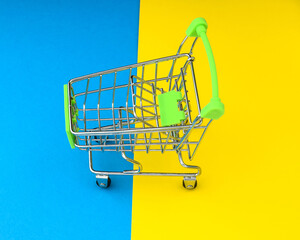Empty shopping cart isolated on yellow and blue background. The concept of buying and selling goods...