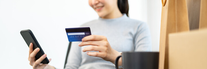 Close up hand using mobile phone and credit card for online payment, electronic wallet.