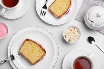 Tasty breakfast with sweet cake and aromatic tea on white table, flat lay