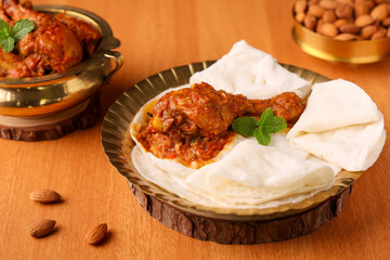 Rice pathiri flat bread with spicy chicken leg curry golden plate Kerala Tamil Nadu India SriLanka. traditional South Indian breakfast dish Malabar Muslims on Ramadan Ramzan, Eid festival Rice roti