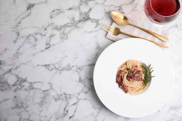 Delicious Carbonara pasta served on white marble table, flat lay. Space for text
