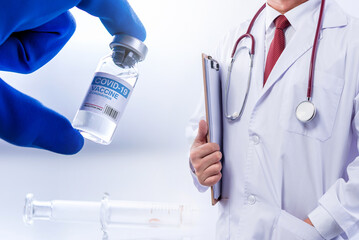 Fototapeta premium Concept fight against virus covid-19 corona virus, doctor with a stethoscope on shoulder holding syringe and COVID-19 vaccine adults, Concept: diseases, medical care, science.