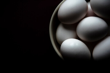 Dramatic white eggs in a plate on a dark background