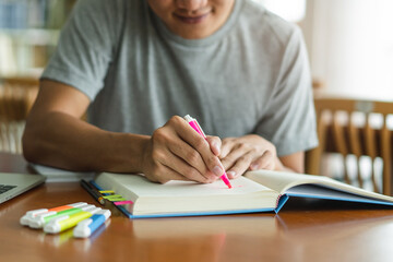 male asian student studying and reading book in library