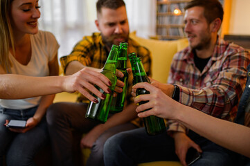 Group of happy friends drinking and toasting beer