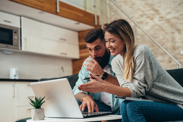 Couple using a laptop while working on their home finances