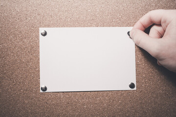 Hand Pinning A Blank Paper Note With Copy Space To A Cork Board - Reminder Concept