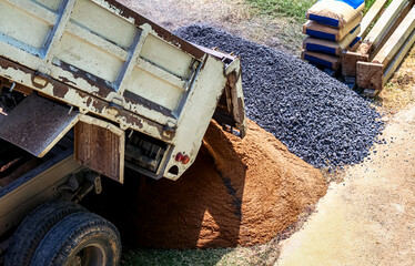 stone, sand pile and pickup truck at construction area, construction concept