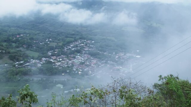 General view of small town in Colombia with moving clouds in foreground
