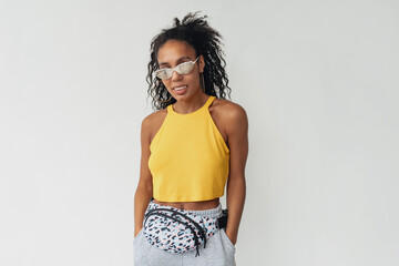 attractive black african american woman posing in stylish hipster outfit on white background