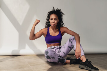 Fototapeta na wymiar attractive black african american woman in stylish hipster fitness outfit on background