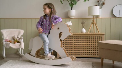 Wide Shot Little Girl Riding a Toy Horse at Light Apartment