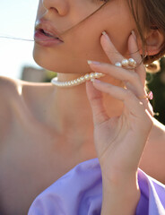 Blonde neck woman with pearl necklace and ring at outdoor