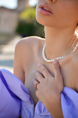 Blonde neck woman with pearl necklace and ring at outdoor