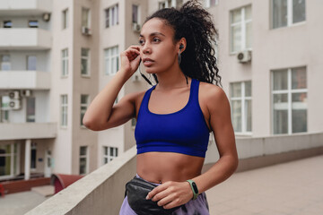 Fototapeta na wymiar attractive black african american woman in sport fitness outfit on rooftop making work out