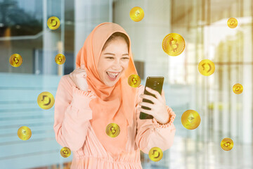 Happy Muslim woman getting cryptocurrency coins