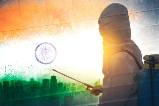 Male worker spraying disinfectant to India flag