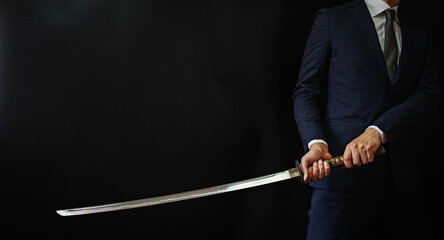 日本刀を構えるスーツの人物
