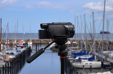 Selective focus view at a camera filming at a yacht port in Kiel in Germany
