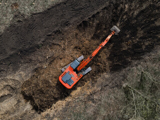 Crawler excavator top view digging on construction site