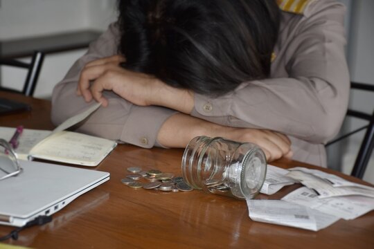 Thai government officials in uniform are stressed by lack of money, indicating the poor financial condition in the household.