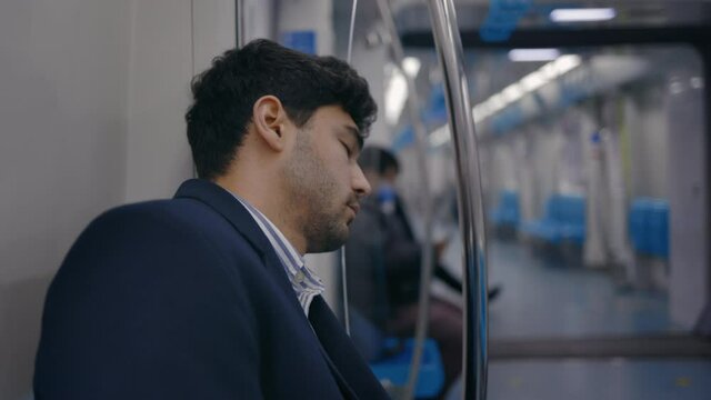 Tired man in business suit sleeping in subway car