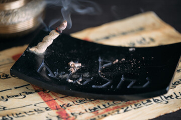 Tibetische Räucherschnur auf schwarzem Specksteinhalter mit tibetischem Text