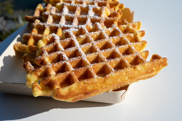 Sweet fresh baked Belgian waffles served outdoor with view on Maas river in Dinant, Wallonia, Belgium.