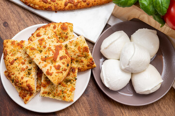 Tasty italian vegetarian food, fresh baked flat foccachia bread with white mozzarella cheese and herbs